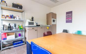 Furnished office pantry at Nusterweg 63 in Sittard, ideal for those seeking office space rental with appliances and seating area.