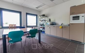 Bright office kitchen with a table and chairs at Nusterweg 63, Sittard, ideal for renting office space. Modern appliances and natural light make it a welcoming environment.