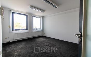 Unfurnished office space available for rent at Nusterweg 63 in Sittard, featuring large windows allowing natural light.