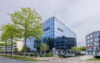 Modern glass office building at Curieweg 9, Spijkenisse, available for office space rental.