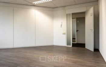 An unfurnished office space with wooden flooring and white walls, offering potential for tailored office space rental at Curieweg 9, Spijkenisse.