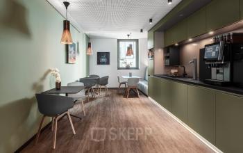 Moderner und sauberer Loungebereich mit Sitzgelegenheiten und Kaffeemaschine im Bürogebäude an der Königstraße 38, Stuttgart Mitte.