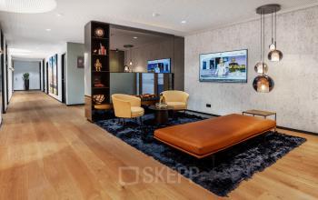 Moderne Bürofläche mieten in Stuttgart Mitte, Königstraße 38. Stilvolle Lounge mit bequemen Sitzgelegenheiten und großen Flachbildschirmen.