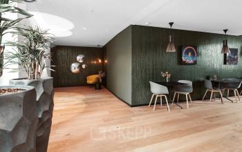 Modernes büroraum mieten in der Königstraße 38, Stuttgart Mitte. Ein stilvoll eingerichteter Arbeitsplatz mit Holzboden, modernen Stühlen und Pflanzen.