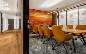 Büroraum in Königstraße 38, Stuttgart Mitte mit modernem Konferenztisch und orangenen Stühlen, natürlichem Licht und ansprechender Wandgestaltung.