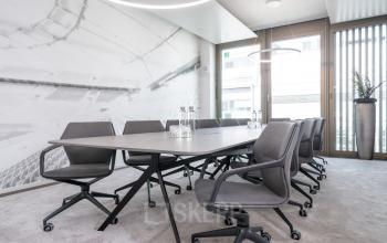 Moderner Konferenzraum im Bürogebäude Königstraße 35, Stuttgart Mitte, ideal um Büroraum zu mieten. Elegante, graue Stühle und ein großer Besprechungstisch dominieren den Raum, perfekt für Meetings.