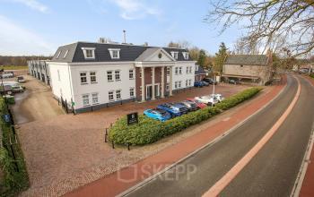 Office building at Bredaseweg 8, Breda Terheijden featuring a classic facade and ample parking. Ideal office space rental opportunity in a well-connected location.