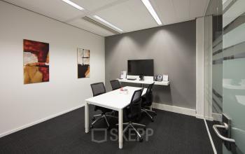 Modern office space rental at Hart van Brabantlaan 12-16, Tilburg, with sleek furniture and vibrant art on the walls.
