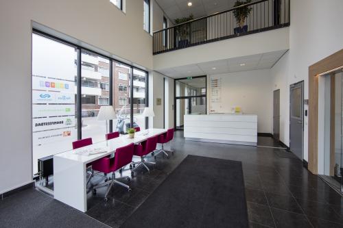 Spacious reception area with modern furnishings at Hart van Brabantlaan 12-16 office space rental in Tilburg, featuring seating and bright lighting.