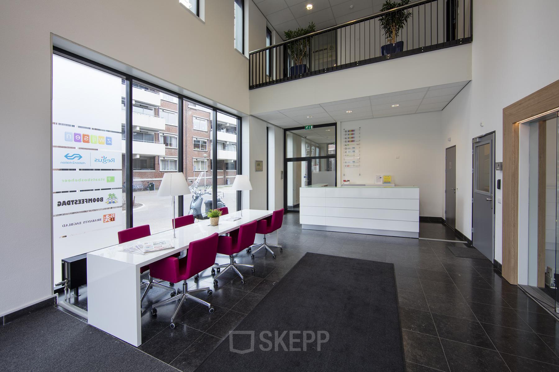Spacious reception area with modern furnishings at Hart van Brabantlaan 12-16 office space rental in Tilburg, featuring seating and bright lighting.