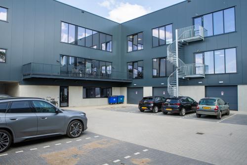 Exterior view of the office building at Kapitein Rondairestraat 8, Tilburg, featuring a parking area and a modern design, highlighting available office space rental options.