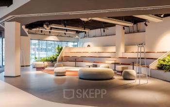 Stylish and modern office space for rent at Daalsesingel 51, Utrecht Central Station, featuring a furnished open floor plan with seating and plants.