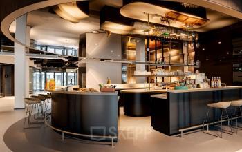Modern workspace featuring a stylish bar area with stools, ideal for office space rental at Daalsesingel 51, Utrecht Central Station.