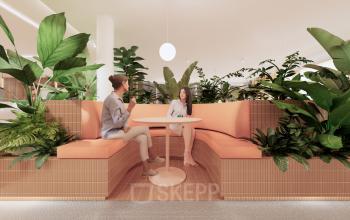Modern office lounge at Moreelsepark 1, Utrecht Central Station, featuring vibrant greenery, contemporary seating, and a relaxed atmosphere ideal for informal discussions. Perfect for those seeking office space rental in a prime location.