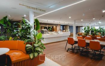 Modern office space rental at Moreelsepark 1, Utrecht Central Station, featuring stylish furnishings and vibrant greenery for a dynamic work environment.