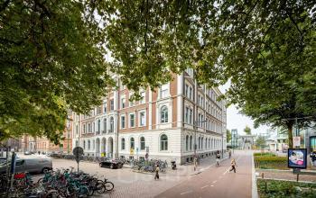 Exterior view of office building at Moreelsepark 1, Utrecht Central Station, showing a potential office to rent amidst a bustling urban environment.