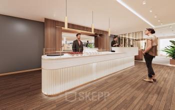 Modern reception area at Moreelsepark 1, Utrecht Central Station with wooden floors, sleek reception desk, and overhead lighting. Two people engage in business-related activities, creating a welcoming office space rental atmosphere.