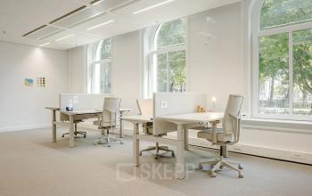 Bright office space at Moreelsepark 1, Utrecht Central Station, with large windows and desks for rent.