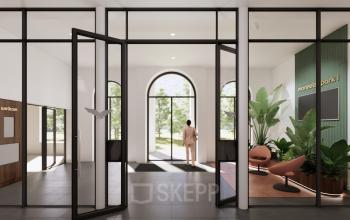 Modern office entrance at Moreelsepark 1, Utrecht Central Station with sleek glass doors, plants, and seating area. Ideal office space rental location with natural light and contemporary design.