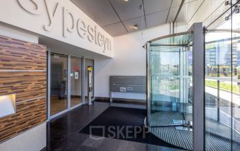 Entrance area at Jaarbeursplein 22 in Utrecht Central Station featuring a modern revolving door and spacious design, ideal for those seeking office space rental opportunities.