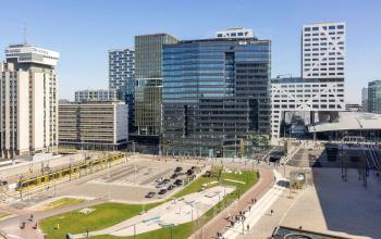 View of Jaarbeursplein 22 at Utrecht Central Station with surrounding modern office buildings and a tram station.