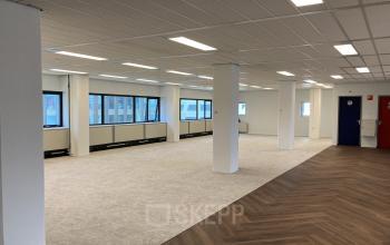Spacious, well-lit office space at Jaarbeursplein 22, Utrecht Central Station, available for rent with large windows and modern flooring.
