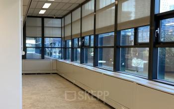 Interior view of office space for rent at Jaarbeursplein 22, Utrecht Central Station, featuring large windows with natural light and ample floor area.