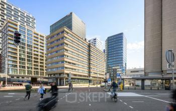 Exterior view of an office building at Jaarbeursplein 22, Utrecht Central Station, showcasing a modern high-rise structure in a bustling urban setting suitable for office space rental.