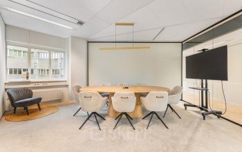 Bright conference room with a large oval table and modern chairs at Leidseveer 2-10. Ideal office space rental located in the heart of Utrecht Central Station.