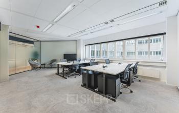 Bright, modern furnished office space available for rent at Leidseveer 2-10, Utrecht Central Station, featuring multiple workstations and large windows providing natural light.