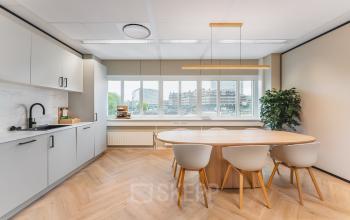 Bright, furnished office space with a wooden table and chairs at Leidseveer 2-10, perfect for renting in Utrecht Central Station.