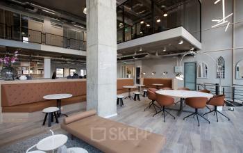 Spacious office interior at Arthur van Schendelstraat 650, in Utrecht Central Station, featuring modern furnishings and open seating areas. Ideal for office space rental.