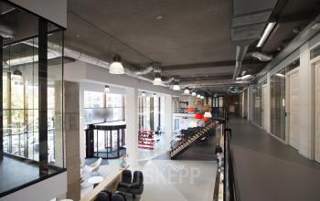 Interior view of office to rent at Arthur van Schendelstraat 650, Utrecht Central Station, featuring modern workspaces with ample natural light and industrial design accents.