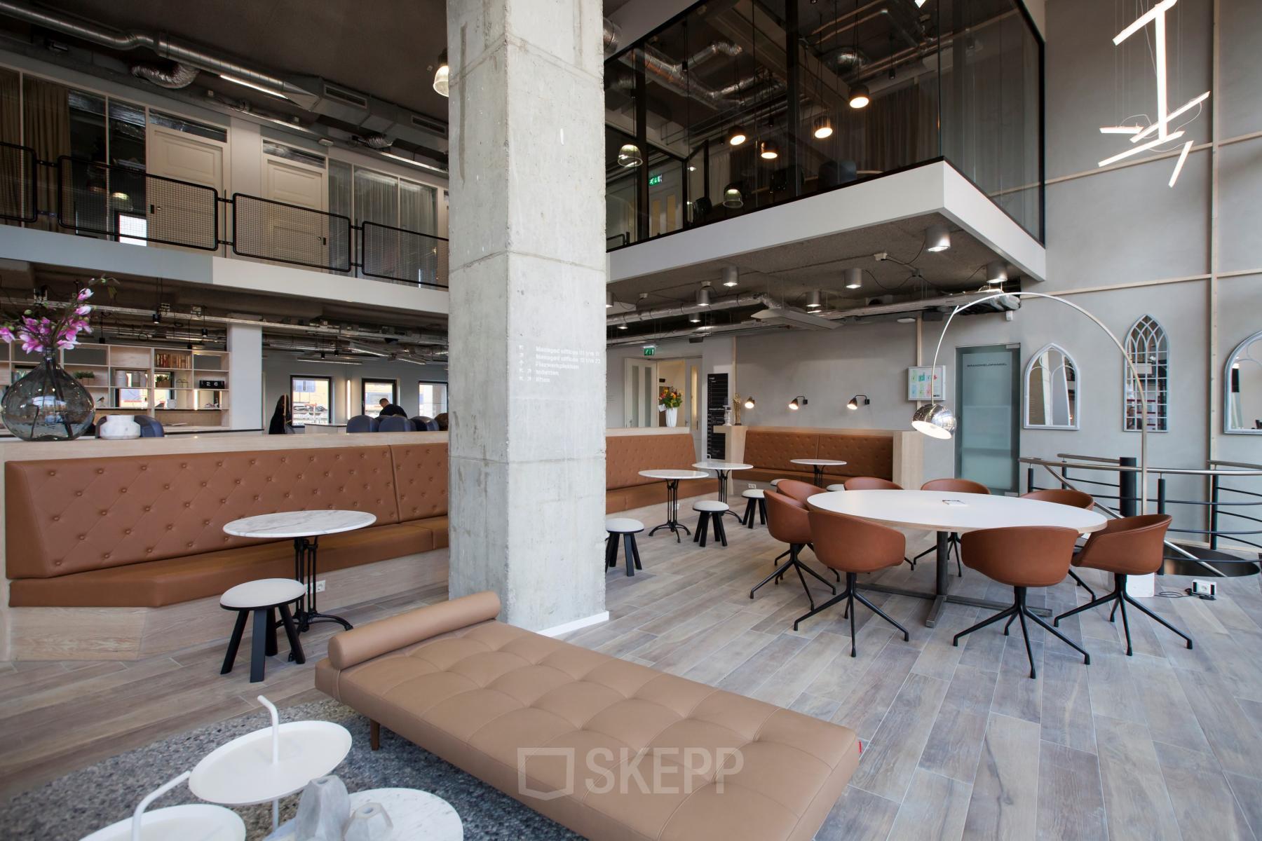 Spacious office interior at Arthur van Schendelstraat 650, in Utrecht Central Station, featuring modern furnishings and open seating areas. Ideal for office space rental.