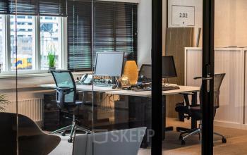 Modern furnished office space for rent at Leidseveer 2-10, Utrecht Central Station, with desks, chairs, and computers in view.