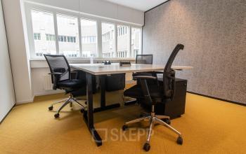 Modern office space rental at Leidseveer 2-10, Utrecht Central Station, Utrecht, featuring two desks with office chairs and a phone.