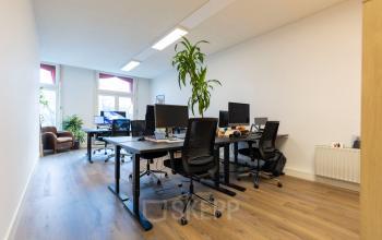 Bright office space at Oudegracht 161, Utrecht Center, featuring desks with computers and chairs, ideal for office space rental needs.