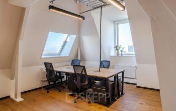 Bright office space rental in Utrecht Center at Nicolaas Beetsstraat 216, featuring wooden floors, large windows, and modern desks and chairs.