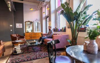 Nicely decorated lounge area with a man working on a laptop in an office building at Nicolaas Beetsstraat 216, Utrecht Center, Utrecht.
