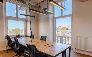 Modern office space rental at Nicolaas Beetsstraat 216, Utrecht Center with large windows, open desks, and ergonomic chairs.