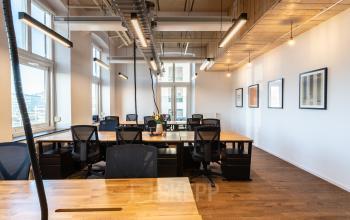 Modern office space for rent at Nicolaas Beetsstraat 216, Utrecht Center, featuring wooden desks, ergonomic chairs, and ample natural light from large windows.