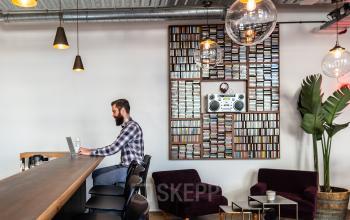 Modern office space at Nicolaas Beetsstraat 216, Utrecht Center, featuring a seating area with unique decor and a bar-like counter with an individual working on a laptop.