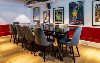 Conference room at Nicolaas Beetsstraat 216 in Utrecht Center with a large table, cushioned chairs, and artistic posters on the wall.