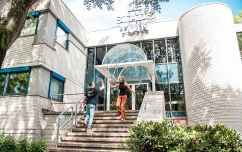 Two people engaged in conversation outside a modern office building at Bernadottelaan 13, Utrecht Kanaleneiland, perfect for office space rental.