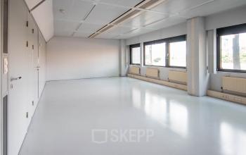 Spacious, unfurnished office space for rent at Bernadottelaan 13, Utrecht Kanaleneiland, featuring large windows providing ample natural light.