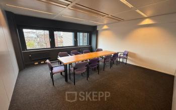 Spacious office to rent in Utrecht Kanaleneiland at Bernadottelaan 13 with a large wooden table surrounded by purple chairs, ideal for meetings.