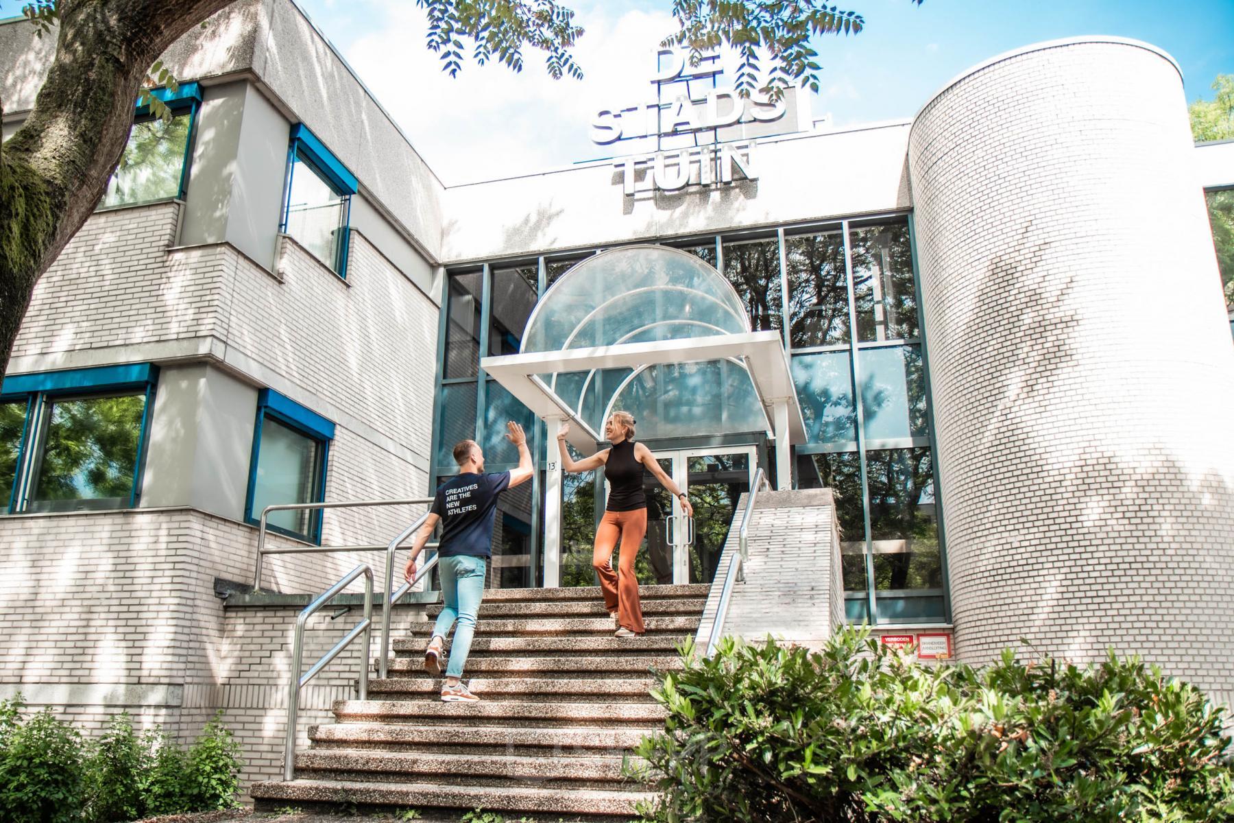 Two people engaged in conversation outside a modern office building at Bernadottelaan 13, Utrecht Kanaleneiland, perfect for office space rental.
