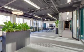 Modern office space rental at Europalaan 400 in Utrecht Kanaleneiland, featuring bright interiors with glass partitions, contemporary lighting, and greenery to enhance the environment.