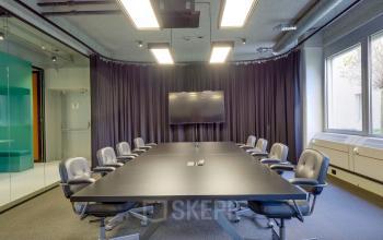 Modern conference room at Europalaan 400 in Utrecht Kanaleneiland, featuring a large table with several chairs, a wall-mounted screen, and ample natural light, ideal for office space rental.