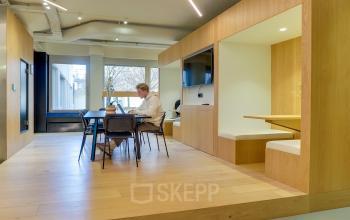 Modern office space to rent at Europalaan 500, Utrecht Kanaleneiland, featuring sleek wooden interiors, natural light, and a collaborative work area with people engaged in business activities.